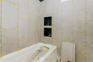 Laying tiles in the bathroom construction floor and wall ceramic tiles installation unfinished